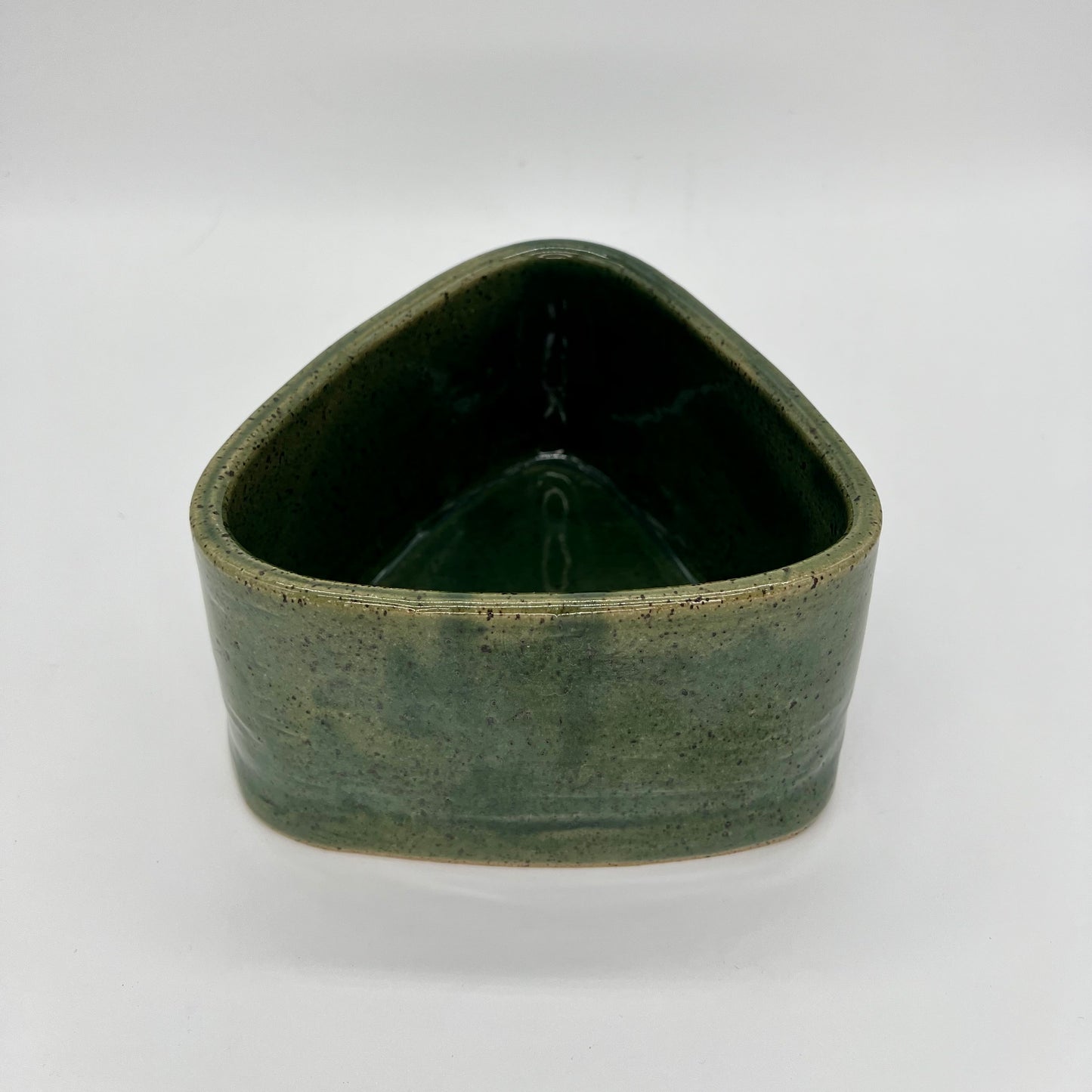 Small planter that combines wheel and hand building techniques and finished in green glaze. Does not feature drainage holes, so use pebbles in the base below the soil, to catch excess water.