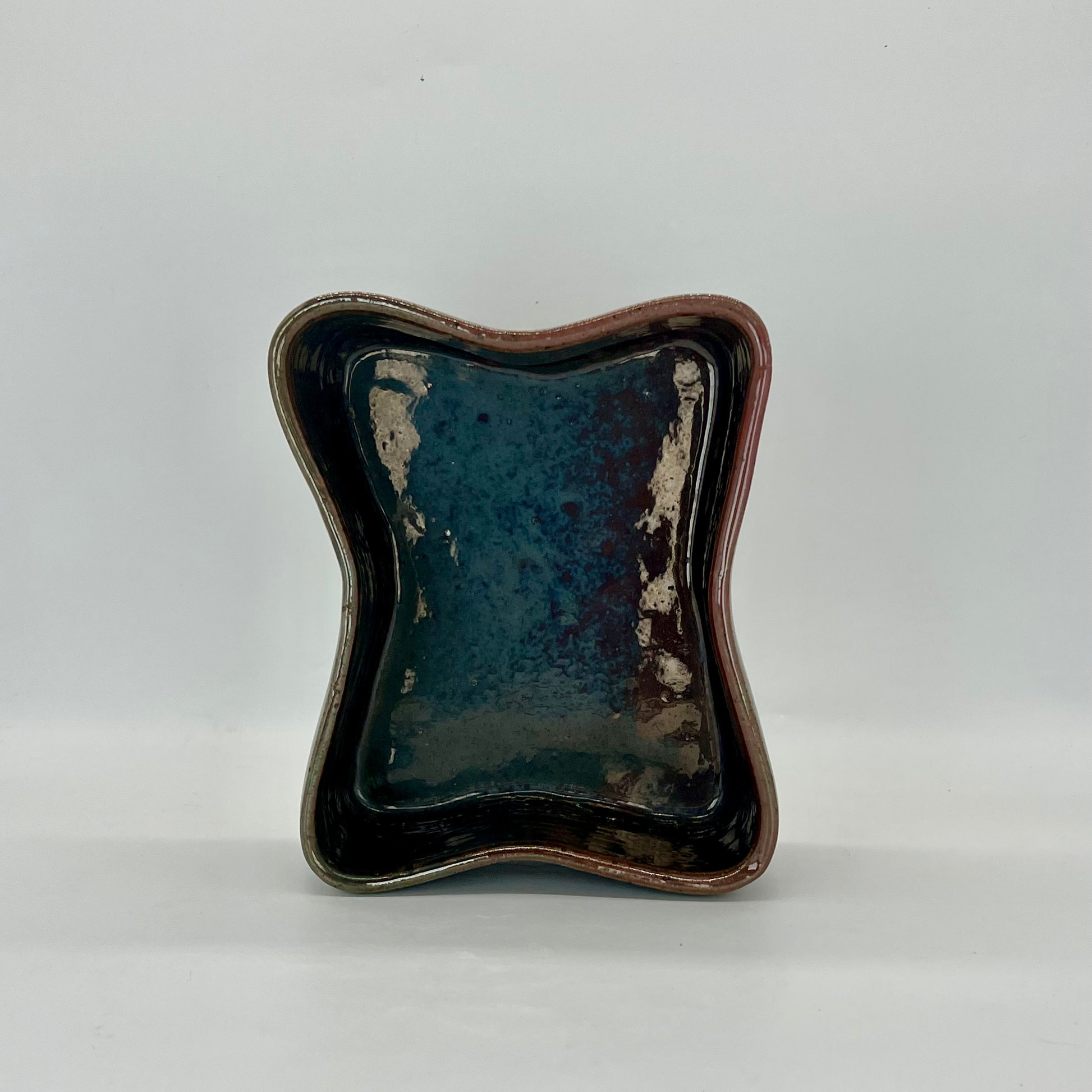 Butterfly-shaped planter. Finished in orbit glaze that is iridescent with coppers, browns, and blues.