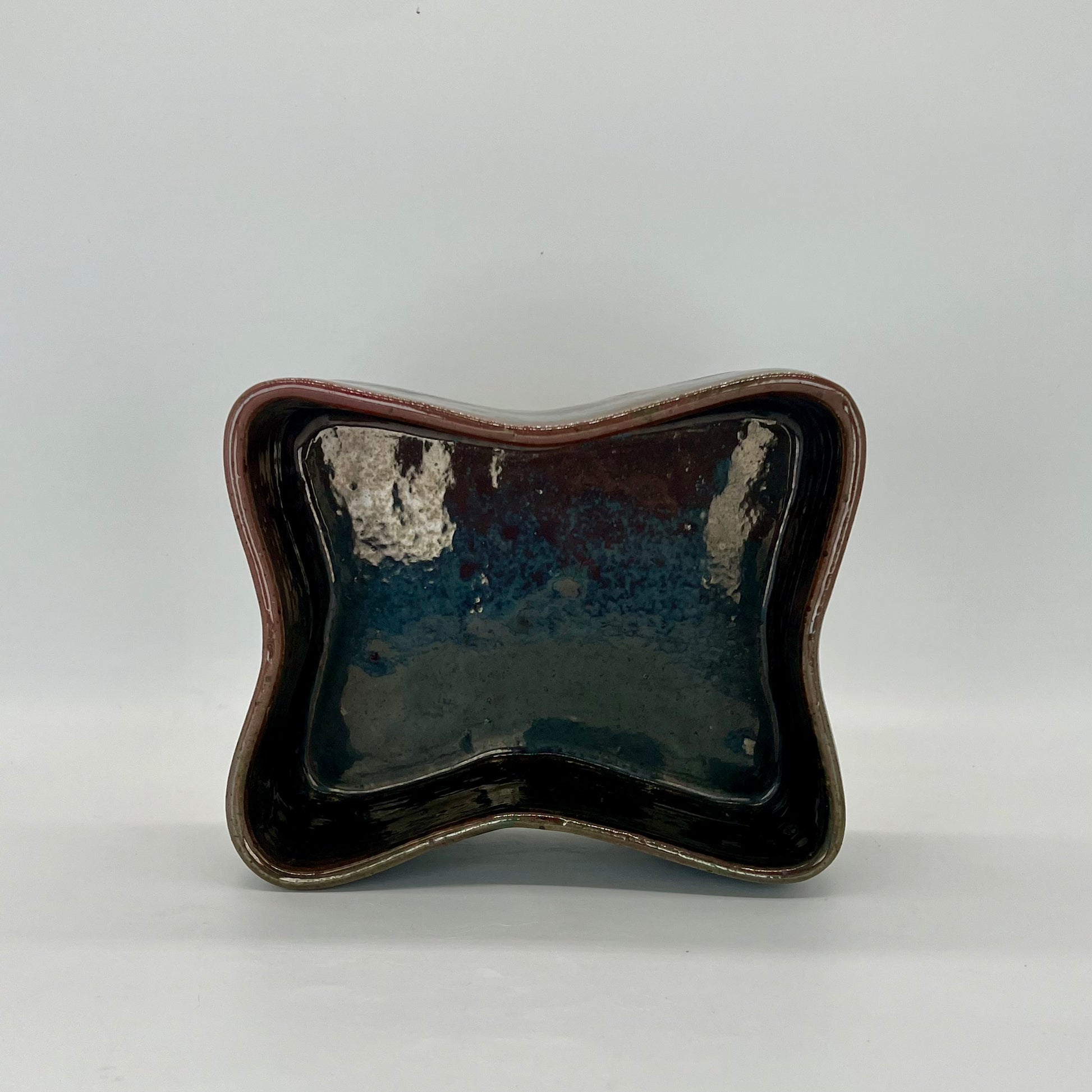 Butterfly-shaped planter. Finished in orbit glaze that is iridescent with coppers, browns, and blues.