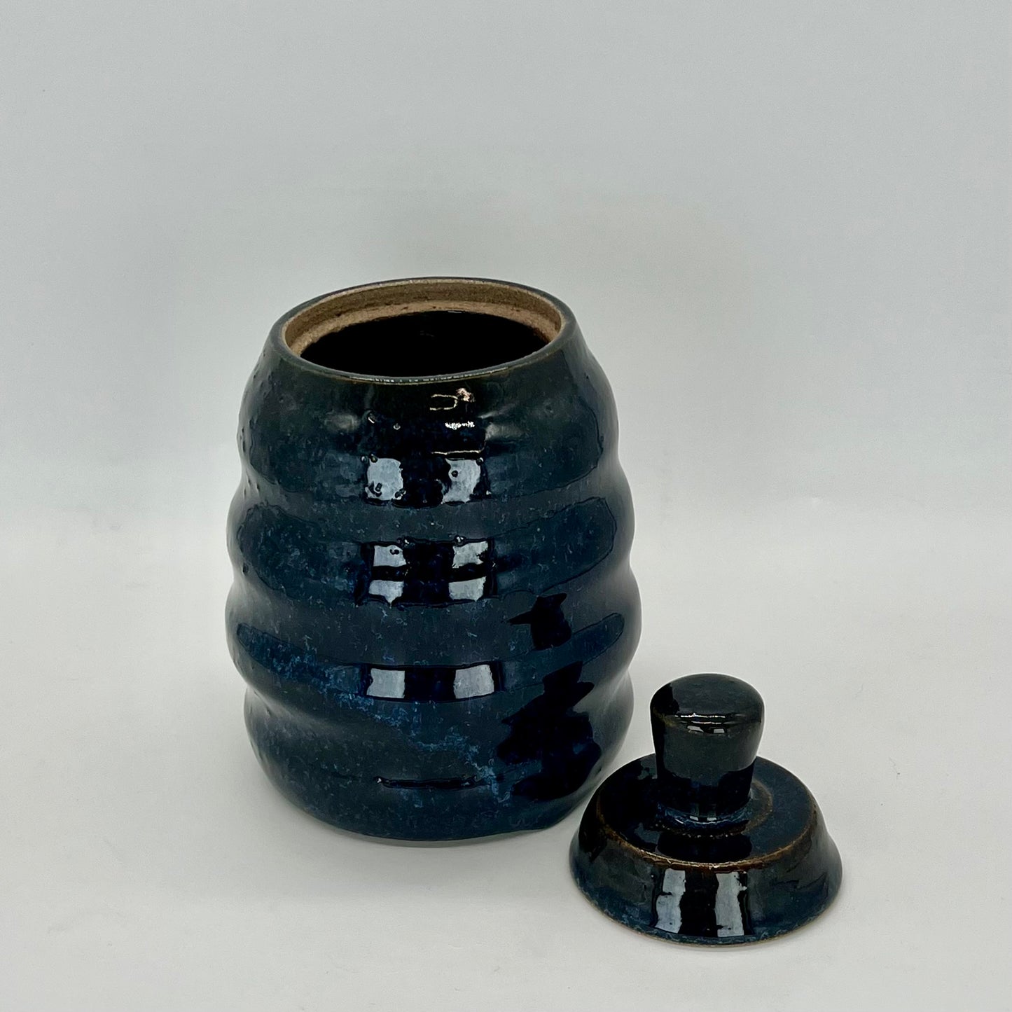 Honeycomb-shaped jar with lid. Deep midnight blue glaze. Ideal for pet treats or cookies.