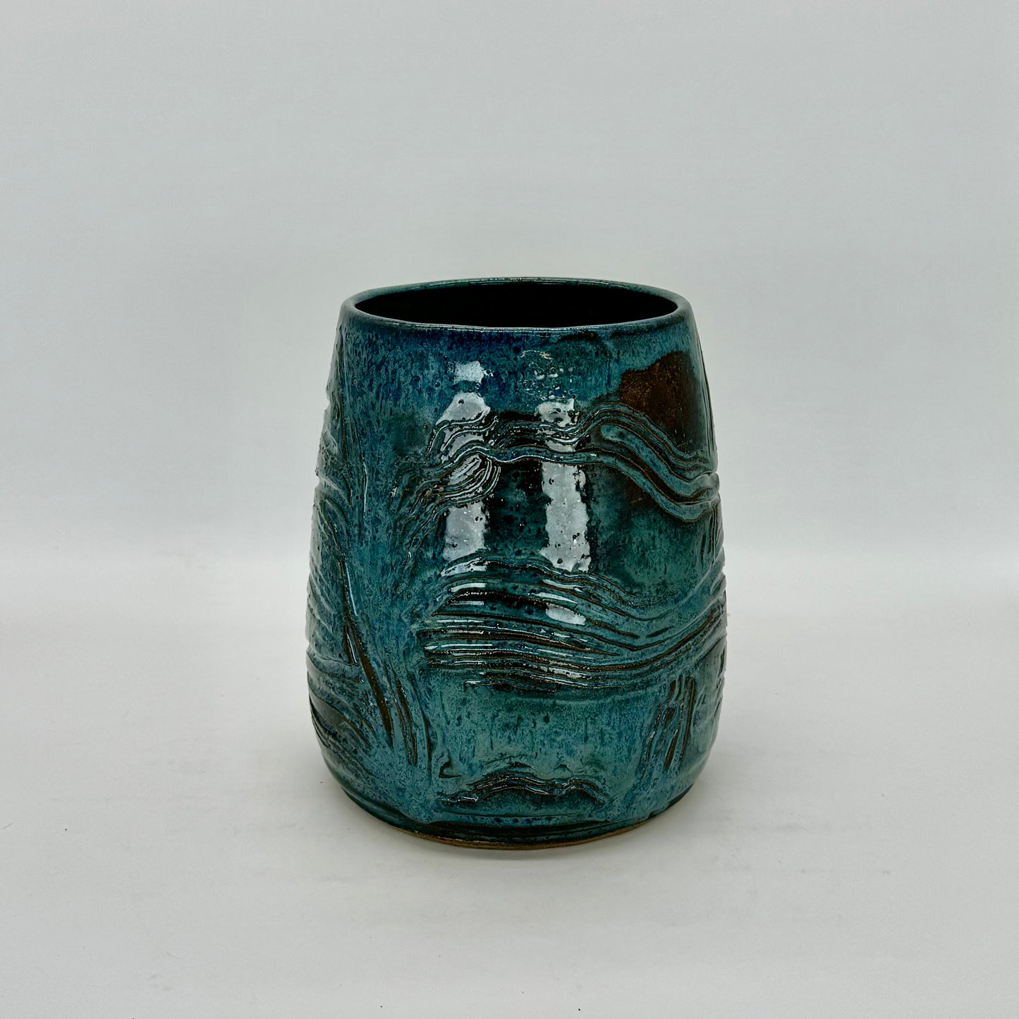 Large carved barrel vase inspired by sedimentary rocks found on the North Fork of Long Island. Finished in misty blue glaze.