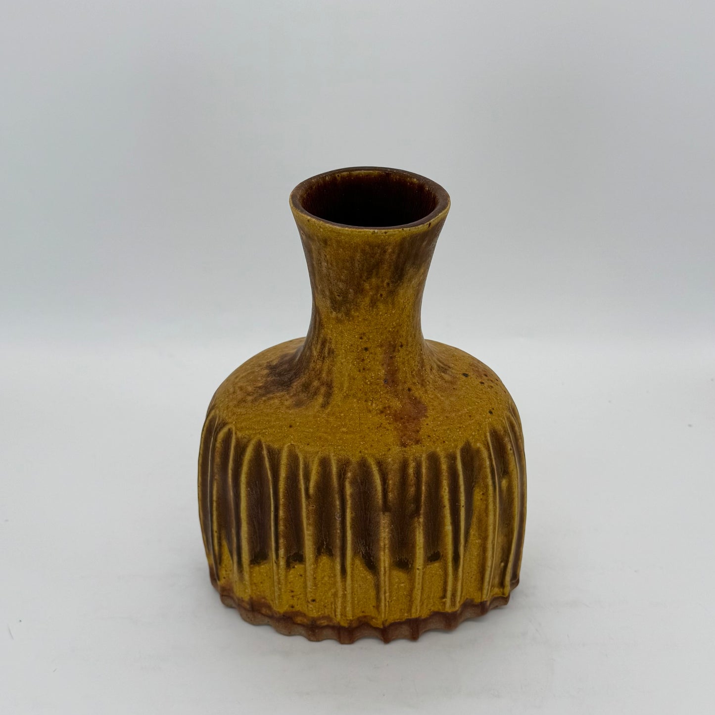 Hefty Woo Yellow Fluted Vase thrown on wheel, shaped after firming up, with a slab base and exaggerated neck. Thick walls allow for deep flutes around the base. Finished in a deep amber matte glaze.