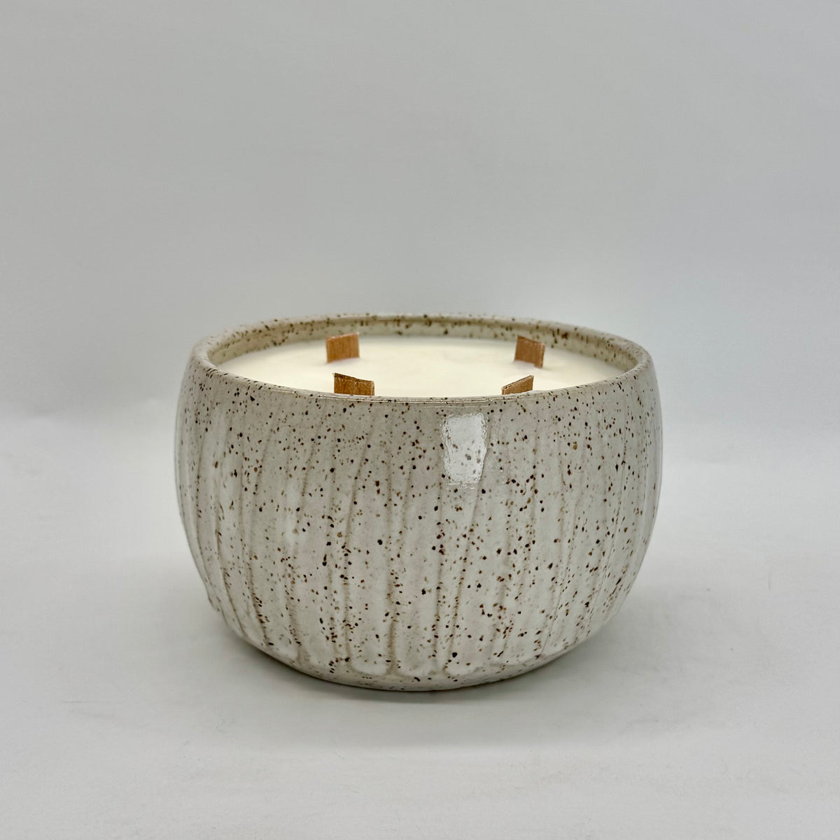 55 oz. Radiant Rose soy candle poured in one-of-a-kind fluted, speckled-white vessel