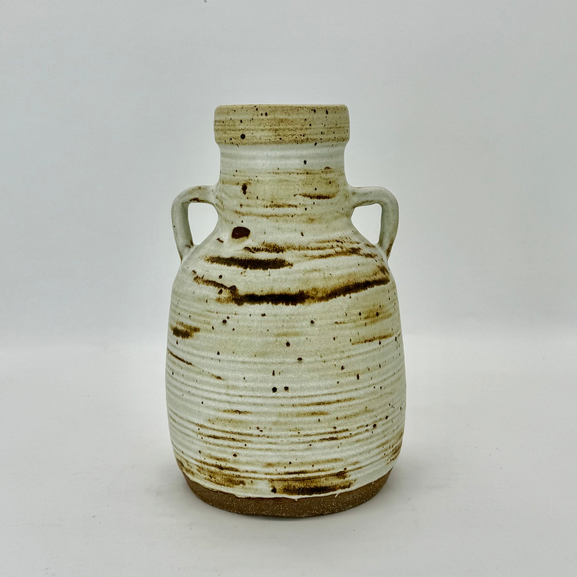 Large jug with handles, textured with subtle rings, featuring iron oxides under speckled cream matte finish.