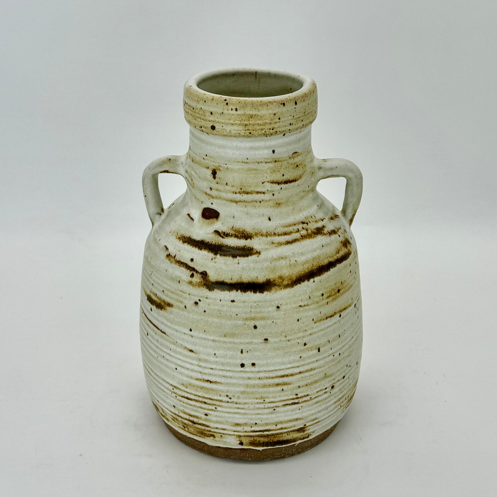 Large jug with handles, textured with subtle rings, featuring iron oxides under speckled cream matte finish.