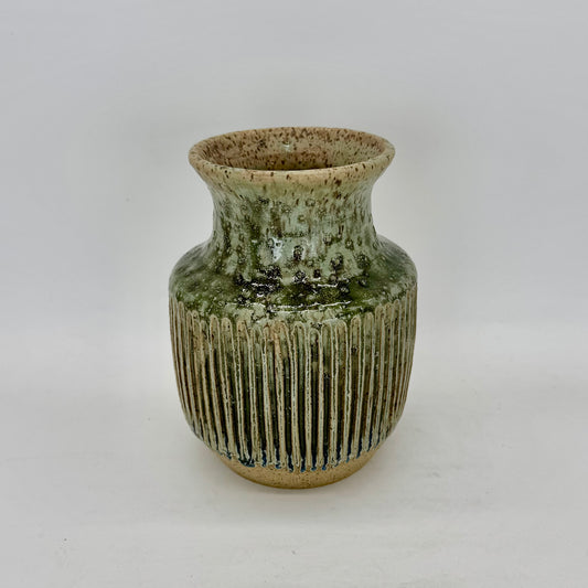 With a silhouette inspired by classic Art Deco design, this vase features tight, elegant fluting that enhances the flow of its pale seaweed green glaze. The carved ridges invite the glaze to pool and deepen, revealing subtle tonal shifts and at the base of the fluting, a surprising transformation into a deep blue, adding depth and intrigue to the form. Brian Burgess Ceramics makes handcrafted stoneware ceramics on the North Fork of Long Island, New York, for the garden, home and table. Buy local. Support sm