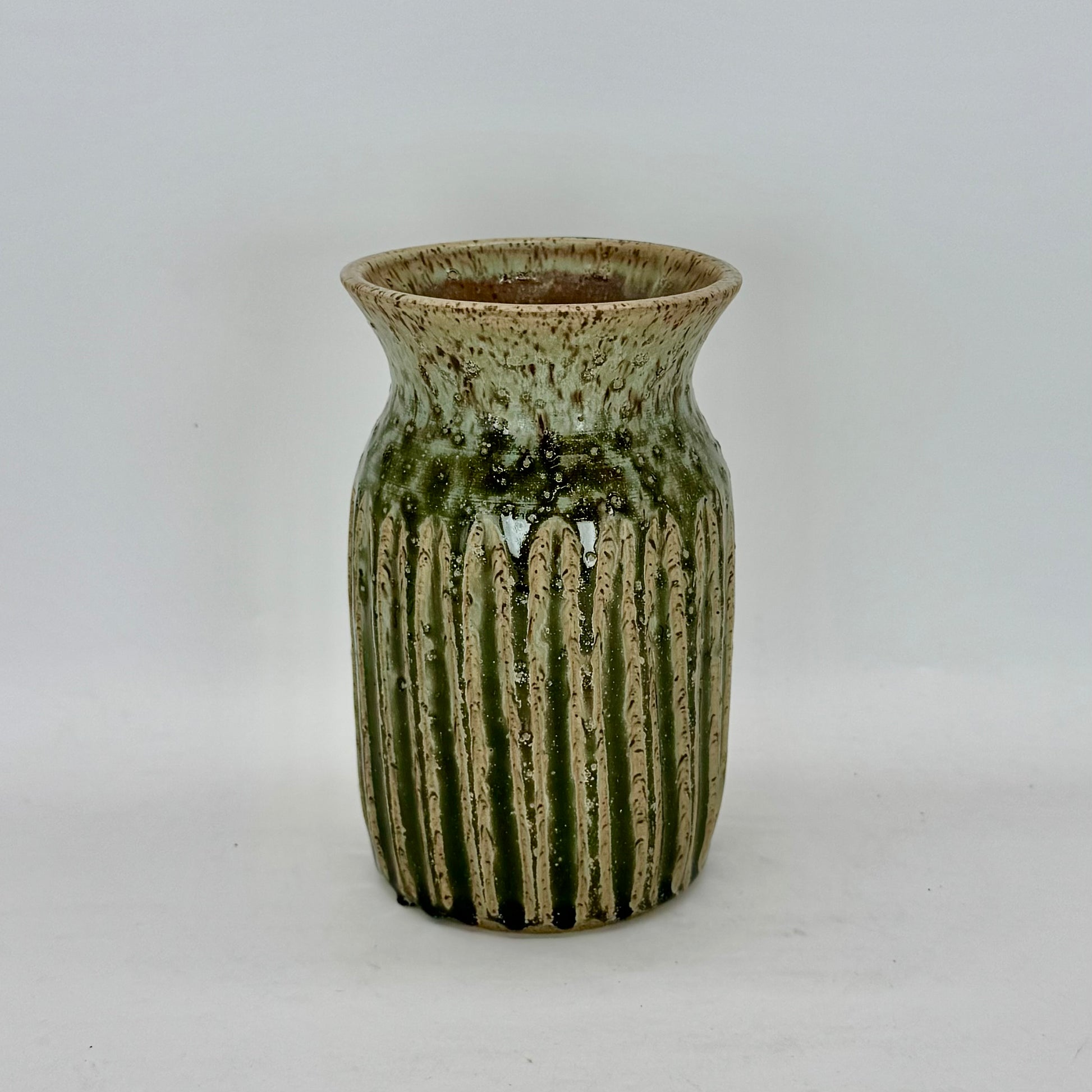 This classic-shaped vase features fluting that highlights the beauty of its pale seaweed green glaze. The carved details allow the glaze to pool and deepen, creating subtle variations in tone and texture that add depth and visual interest. Brian Burgess Ceramics makes handcrafted stoneware ceramics on the North Fork of Long Island, New York, for the garden, home and table. Buy local. Support small businesses. Handmade. Small batch. 