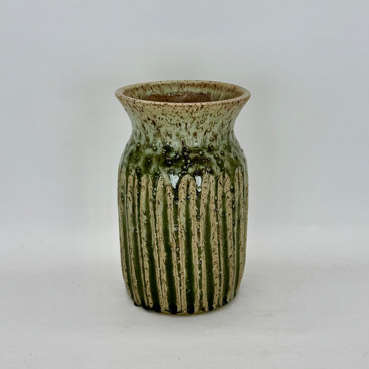 This classic-shaped vase features fluting that highlights the beauty of its pale seaweed green glaze. The carved details allow the glaze to pool and deepen, creating subtle variations in tone and texture that add depth and visual interest. Brian Burgess Ceramics makes handcrafted stoneware ceramics on the North Fork of Long Island, New York, for the garden, home and table. Buy local. Support small businesses. Handmade. Small batch. 
