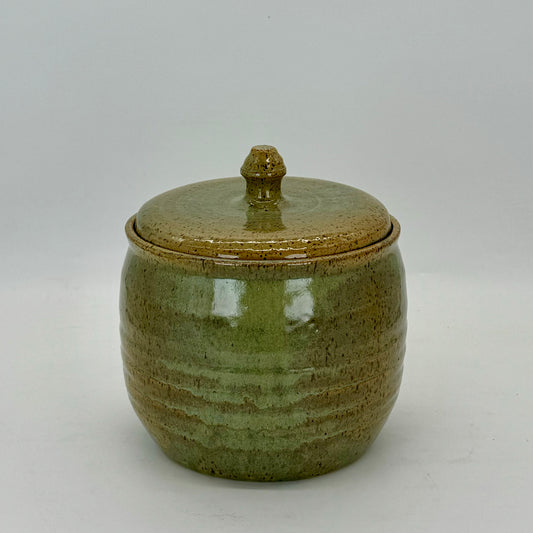 Speckled green treat jar with subtle rings around the vessel. Sea mist inspired glazed.