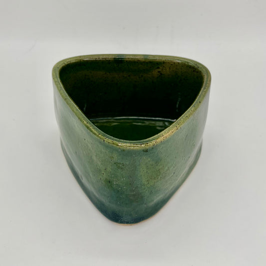 Small planter that combines wheel and hand building techniques and finished in green glaze. Does not feature drainage holes, so use pebbles in the base below the soil, to catch excess water.