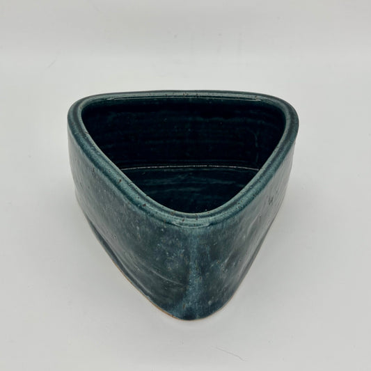 Small planter that combines wheel and hand building techniques and finished in blue glaze. Does not feature drainage holes, so use pebbles in the base below the soil, to catch excess water.