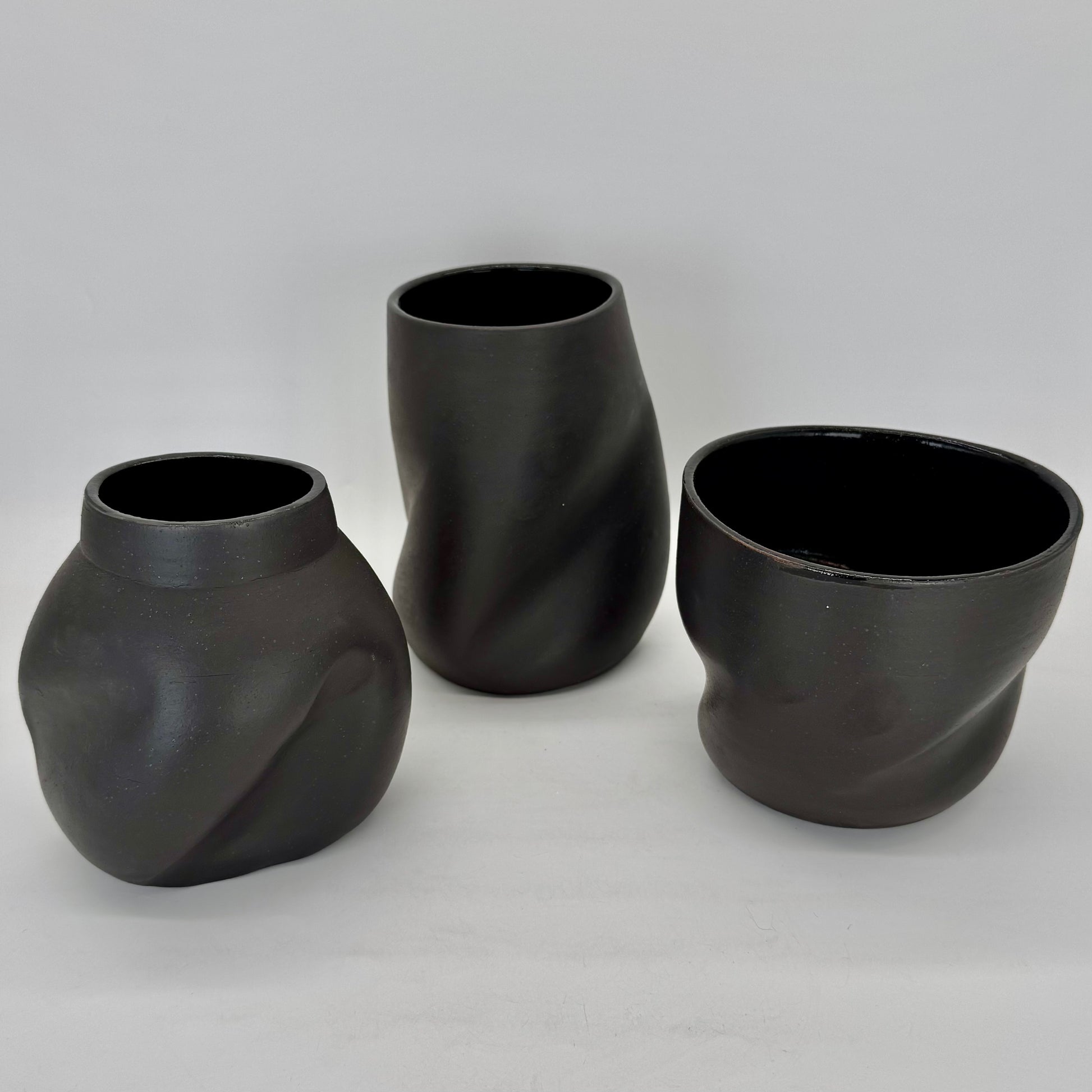 Dark and distorted vase. Set of Terra Sigillata (terra sig), an old Roman technique of applying a clay and water slip before firing, giving the final firing a deep, dark matte finish