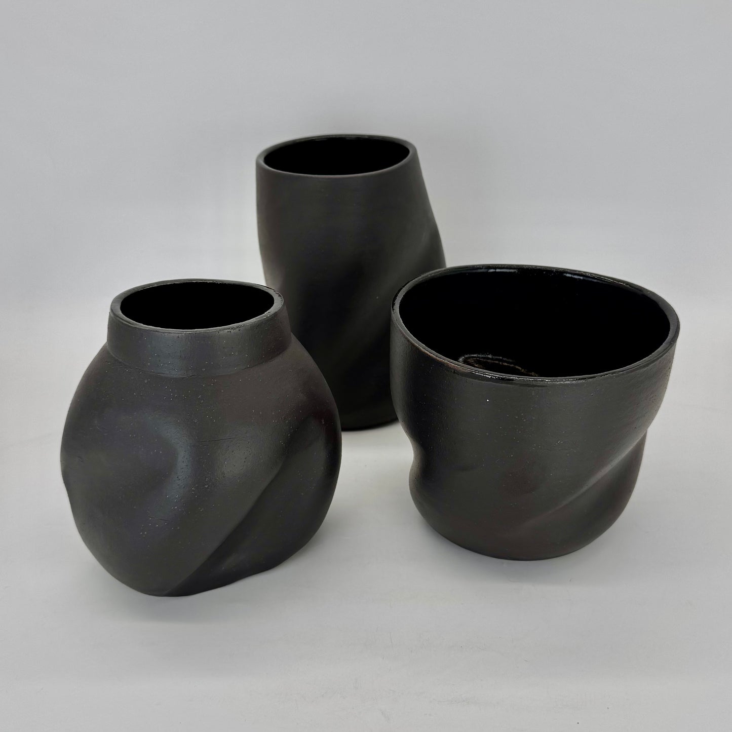 Dark and distorted vase. Set of Terra Sigillata (terra sig), an old Roman technique of applying a clay and water slip before firing, giving the final firing a deep, dark matte finish