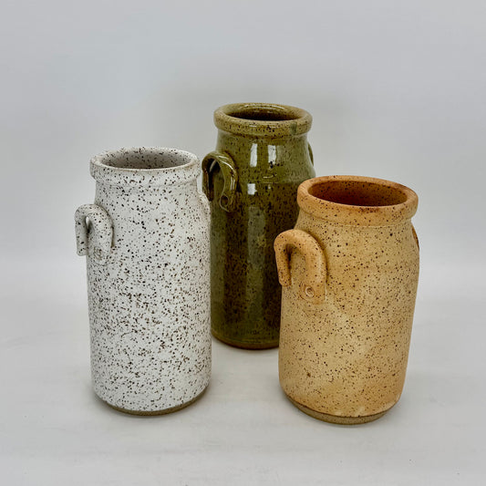 Set of three Classic milk bottle shaped vessel that works as a vase or decorative vessels for the modern farmhouse. Each vase features charming lug handles, and finished in matte white, speckled farm egg and serene sea mist glazes. Brian Burgess Ceramics makes handcrafted stoneware ceramics on the North Fork of Long Island, New York, for the garden, home and table. Buy local. Support small businesses. Handmade. Small batch. 
